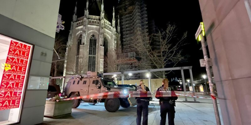 Zwei Polizistinnen stehen hinter einem Absperrband der Polizei am Münsterplatz. - Foto: Nico Pointner/dpa