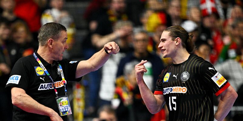 Bundestrainer Alfred Gislason (l) und Juri Knorr sprechen während eines Spiels miteinander. - Foto: Tom Weller/dpa