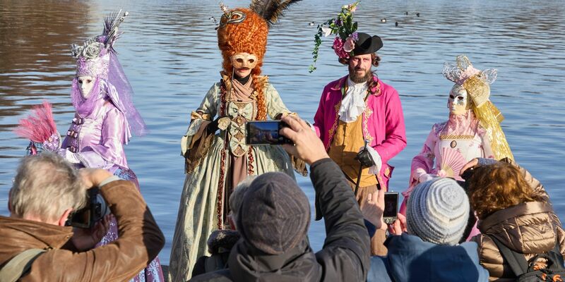 Verkleidete Karnevalfans haben viele neugierige Zuschauer an der Binnenalster in Hamburg. - Foto: Georg Wendt/dpa