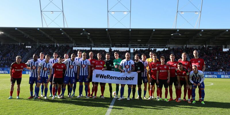 Die Teams von Hertha BSC und SV Wehen Wiesbaden gedenken gemeinsam an die Opfer des Nationalsozialismus. - Foto: Jörg Halisch/dpa