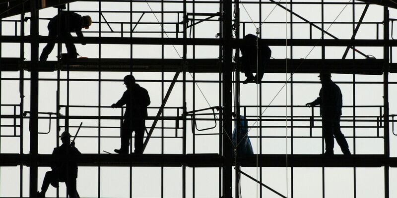 Arbeiter montieren auf einem Gerüst die Glasfassade des Bahnhofs von Frankfurt am Main. - Foto: picture alliance / dpa