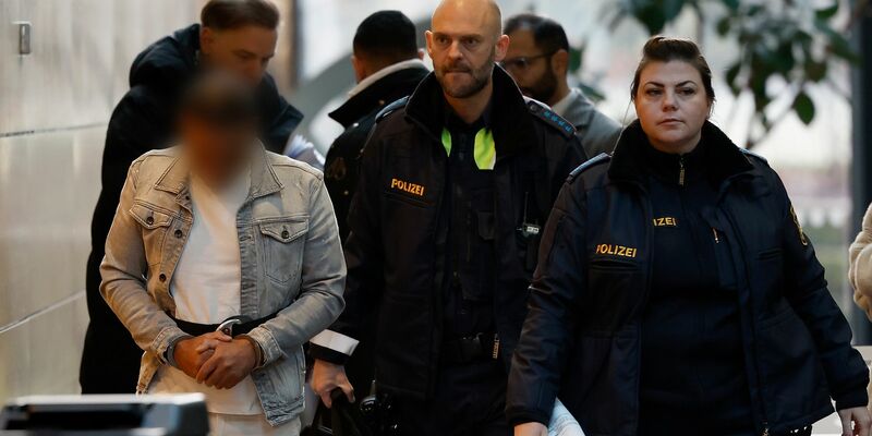 Der Angeklagte (l) wird in Handschellen zum Sitzungssaal im Landgericht Würzburg gebracht. - Foto: Heiko Becker/dpa