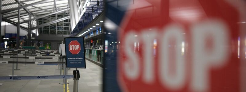 Stop-Schilder in einer leeren Flughafen-Halle. - Foto: Sebastian Willnow/dpa