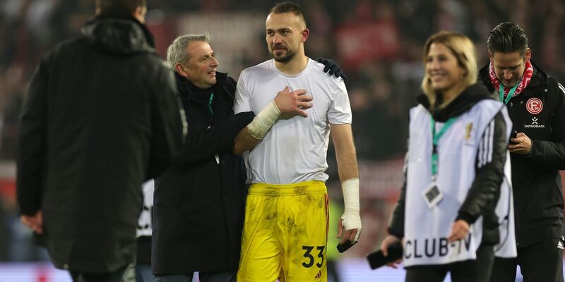 Klaus Allofs (2.v.l.) gratuliert Fortuna-Torwart Florian Kastenmeier zum Sieg. - Foto: Christian Charisius/dpa