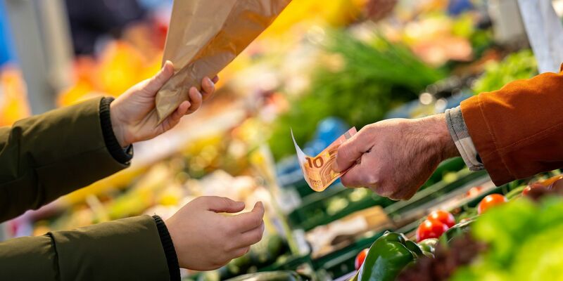 An einem Marktstand wird mit Bargeld eingekauft: Nahrungsmittel verteuerten sich um 3,8 Prozent. - Foto: Sina Schuldt/dpa