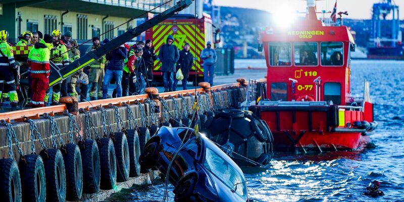 Feuerwehrleute bergen das versunkene Auto aus dem Fjord. - Foto: Håkon Mosvold Larsen/NTB/dpa