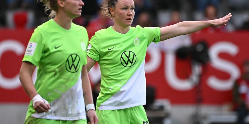 Wolfsburgs Alexandra Popp (r) und Marina Hegering am Spielfeld. - Foto: Angelika Warmuth/dpa