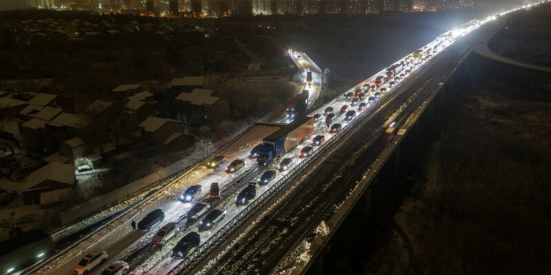 Am Stadtrand von Wuhan stecken die Fahrzeuge auf einer schneebedeckten Schnellstraße fest. - Foto: Chinatopix/AP/dpa