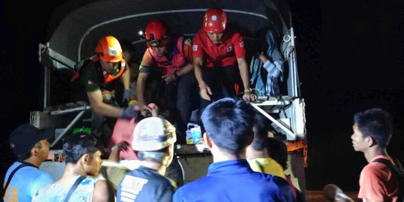Rettungskräfte helfen Bewohnern des Dorfes Maco, sich nach dem Erdrutsch in Sicherheit zu bringen. - Foto: Uncredited/PHILIPPINE RED CROSS/AP/dpa