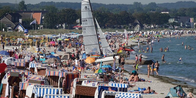 Menschen genießen das Sonnenwetter am Strand der Ostsee. - Foto: Franziska Spiecker/dpa