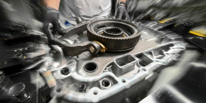 Ein Mitarbeiter montiert in einem Werk ein Getriebe (Symbolbild). - Foto: Felix Kästle/dpa