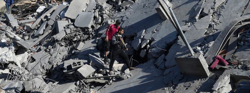 Palästinenser suchen nach einem israelischen Luftangriff im Flüchtlingslager Nusseirat nach Überlebenden. - Foto: Adel Hana/AP/dpa