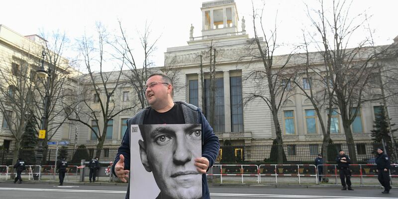 Ein Aktivist steht mit einem Plakat von Kremlkritiker Alexej Nawalny vor der russichen Botschaft in Berlin und protestiert. - Foto: Paul Zinken/dpa