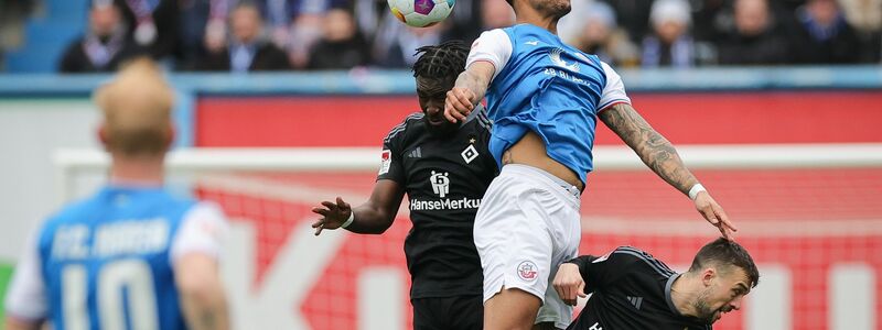 Stephan Ambrosius (l) und der HSV kamen nicht über ein 2:2 in Rostock hinaus. - Foto: Christian Charisius/dpa