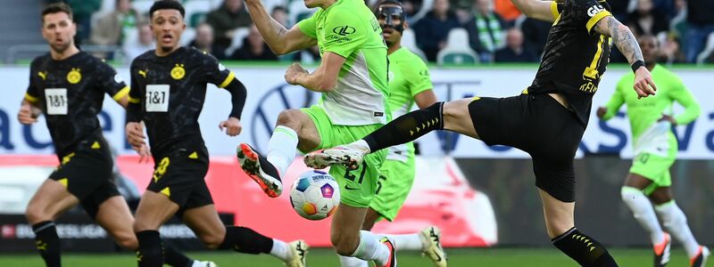 Die Dortmunder um Marco Reus (r) mussten sich in Wolfsburg mit einem 1:1 zufrieden geben. - Foto: Swen Pförtner/dpa