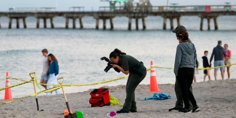 Eine Polizistin macht am Strand von Lauderdale-by-the-Sea Fotos vom Tatort. - Foto: Mike Stocker/South Florida Sun-Sentinel/AP/dpa