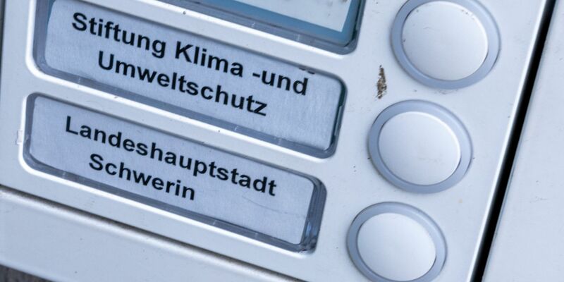 Das Klingelschild der Stiftung Klima- und Umweltschutz am Eingang eines Wohn- und Geschäftshauses. Die geplante Auflösung der Klimastiftung MV ist heftig umstritten. - Foto: Jens Büttner/dpa