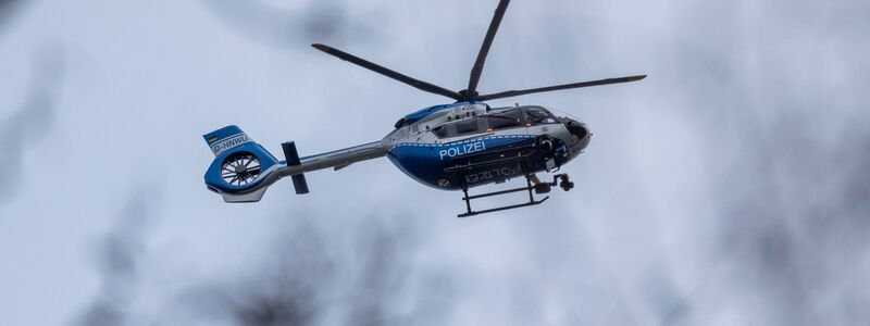 Der Polizei-Hubschrauber kreist über der Schule in Wuppertal. - Foto: Christoph Reichwein/dpa