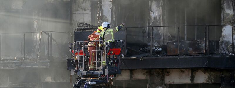 Feuerwehrleute bei den Löscharbeiten auf einer Hubleiter. - Foto: Alberto Saiz/AP/dpa