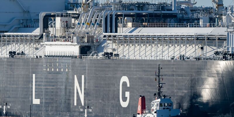 Die fast 300 Meter lange «Energos Power» läuft begleitet von Schleppern in den Hafen von Mukran ein. - Foto: Stefan Sauer/dpa