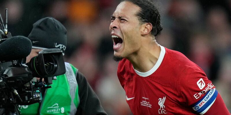 Jürgen Klopp (M) jubelt mit dem Pokal. - Foto: Alastair Grant/AP/dpa