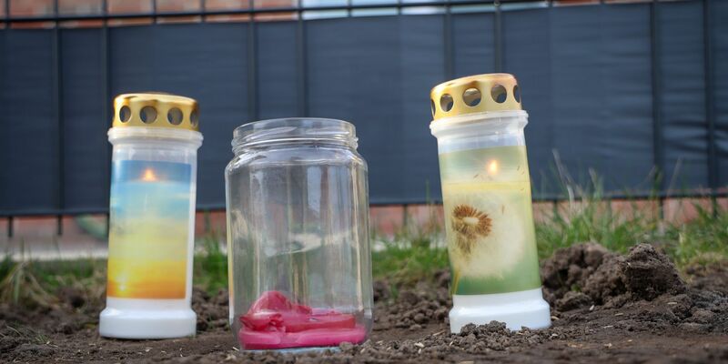 Blumen und Kerzen stehen vor einem Haus in Westervesede in der Gemeinde Scheeßel, in dem ein Mann zwei Personen erschossen haben soll. - Foto: Focke Strangmann/dpa