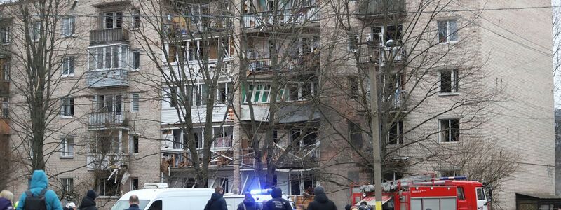 Menschen beobachten, wie Rettungskräfte nach einer Explosion an der Seite des beschädigten Wohnhauses in Sankt Petersburg arbeiten. - Foto: Uncredited/AP