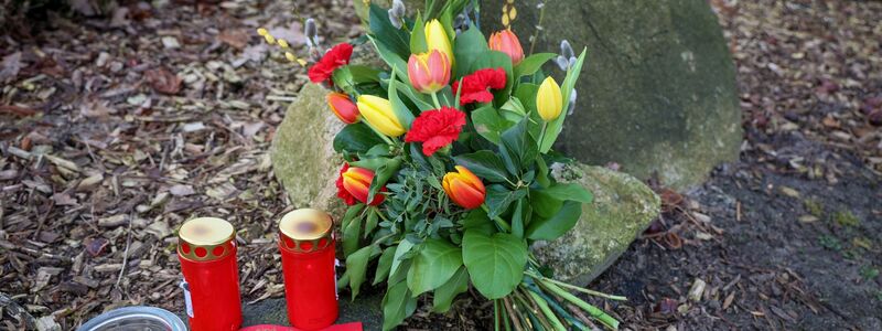 Blumen und Kerzen vor einem Haus in Westervesede in der Gemeinde Scheeßel, in dem am Vortag ein Mann zwei Personen erschossen haben soll. - Foto: Focke Strangmann/dpa