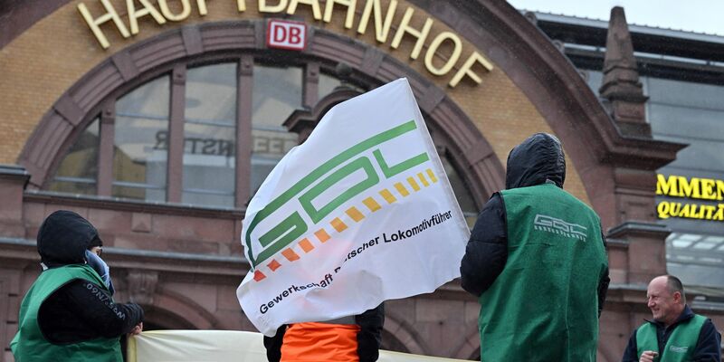 Gewerkschaftsmitglieder stehen vor dem Erfurter Hauptbahnhof. - Foto: Martin Schutt/dpa