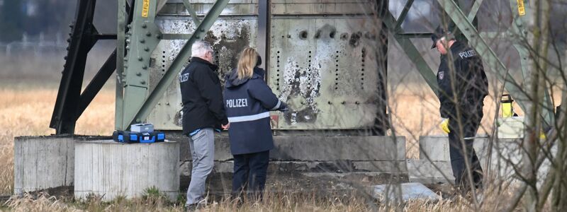 Polizei stehen an dem beschädigten Strommast in Spreenhagen. - Foto: Sebastian Gollnow/dpa