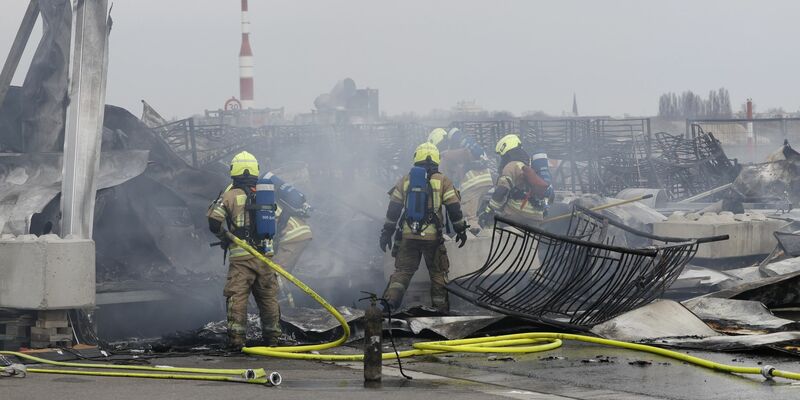 Die Feuerwehr löscht die Brandstelle bei der Flüchtlingsunterkunft am ehemaligen Flughafen Tegel. Die Nachlöscharbeiten sind inzwischen abgeschlossen. - Foto: Carsten Koall/dpa