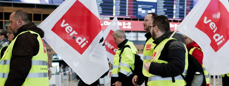 Mitarbeiter des Luftsicherheitspersonals demonstrieren in der Abflughalle im Terminal 1 des Flughafens BER. - Foto: Carsten Koall/dpa
