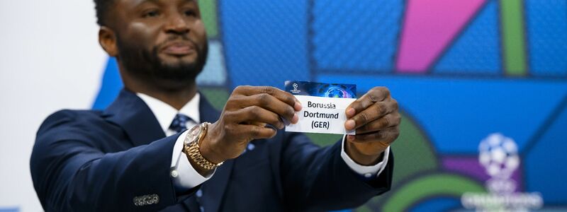 Der ehemalige nigerianische Fußballspieler und Botschafter des Champions-League-Finales in London, John Obi Mikel, zeigt das Los. - Foto: Jean-Christophe Bott/KEYSTONE/dpa