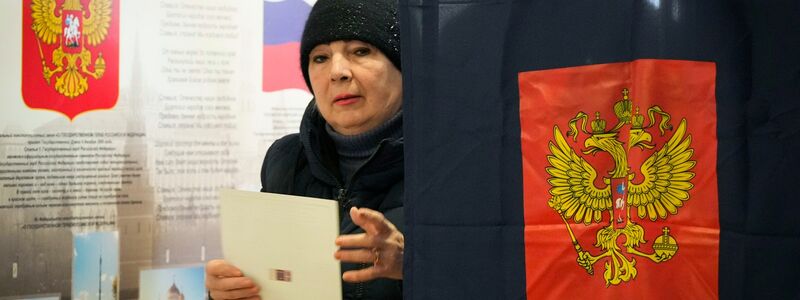 Eine Frau verlässt eine Wahlkabine in einem Wahllokal während der Präsidentschaftswahlen. - Foto: Dmitri Lovetsky/AP