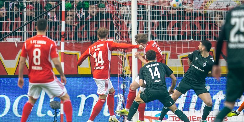 Union-Trainer Steffen Baumgart hat Zeit für einen Handshake mit dem Club-Maskottchen. - Foto: Andreas Gora/dpa