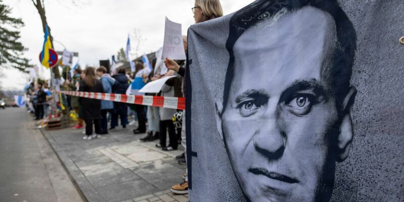 Demonstranten halten vor dem russischen Generalkonsulat in Bonn ein Banner mit dem Porträt des gestorbenen Alexej Nawalny. - Foto: Thomas Banneyer/dpa