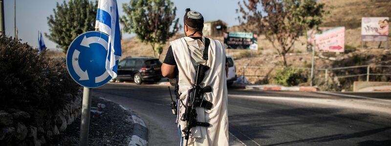 Ein rechtsgerichteter israelischer Siedler trägt eine Waffe nahe der palästinensischen Stadt Nablus im Westjordanland (Archivfoto). Die EU verhängt erstmals Sanktionen wegen der Gewalt radikaler israelischer Siedler. - Foto: Ilia Yefimovich/dpa