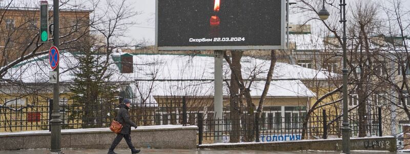 Eine Anzeigetaffel zeigt auf der Straße eine Kerze zum Gedenken der Opfer. Bei dem mutmaßlichen Terroranschlag auf eine Veranstaltungshalle am Stadtrand von Moskau sind mehr als 60 Menschen getötet worden. - Foto: Guo Feizhou/XinHua/dpa