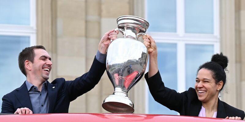 Philipp Lahm, Turnierdirektor der Fußball-Europameisterschaft, hält zusammen mit der früheren Fußball Nationalspielerin Celia Sasic den EM-Pokal hoch. - Foto: Bernd Weißbrod/dpa