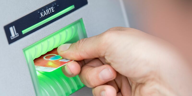 Eine Bankkundin steckt ihre Girokarte in einen Geldautomaten: Seit 2016 hat jeder Bürger in Deutschland Anspruch auf ein Girokonto. - Foto: Fabian Sommer/dpa