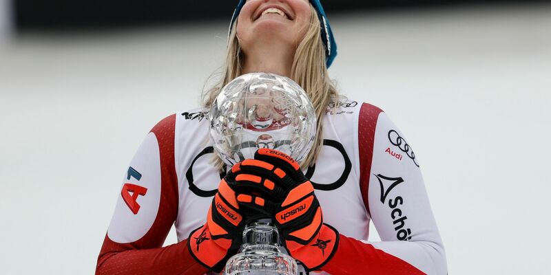 Nach ihrem Abfahrtssieg jubelt Cornelia Hütter mit der Kristallkugel-Trophäe. - Foto: Alessandro Trovati/AP/dpa