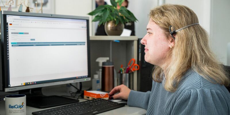 Eva Lenz arbeitet am Empfang der ReiColor Chemie-GmbH. - Foto: Daniel Vogl/dpa