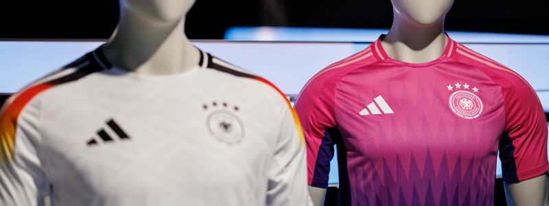 Wurde kontrovers diskutiert: die Farbwahl des neuen Pink und lilafarbenen Auswärtstrikots der deutschen Fußballnationalmannschaft (r). - Foto: Daniel Karmann/dpa