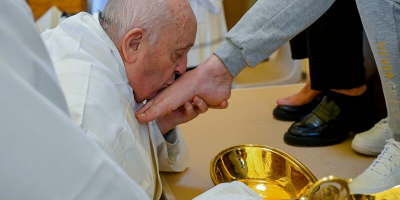 Papst Franziskus küsst den Fuß von einer weiblichen Insassin des Rebibbia-Gefängnisses. - Foto: Vatican Media/AP/dpa