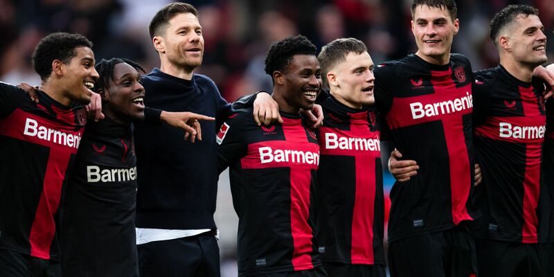 Leverkusens Trainer Xabi Alonso (3.v.l.) feiert nach der Partie mit den Spielern vor der Kurve. - Foto: Marius Becker/dpa