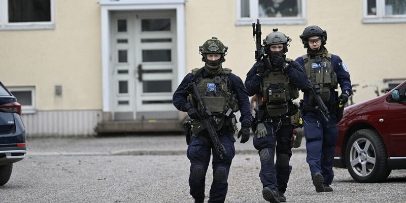 Bewaffnete Polizisten gehen in der Nähe der Viertola-Schule. Bei dem Vorfall an einer Grundschule in der finnischen Stadt Vantaa nördlich von Helsinki sind Kinder verletzt worden. Ein zwölf Jahre altes Kind stirbt. - Foto: Markku Ulander/Lehtikuva/dpa
