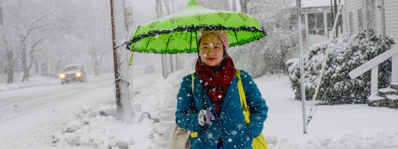 Eine Frau schützt sich in Bellows Falls in Vermont mit einem Schirm vor den Schneeflocken. - Foto: Kristopher Radder/The Brattleboro Reformer/AP/dpa