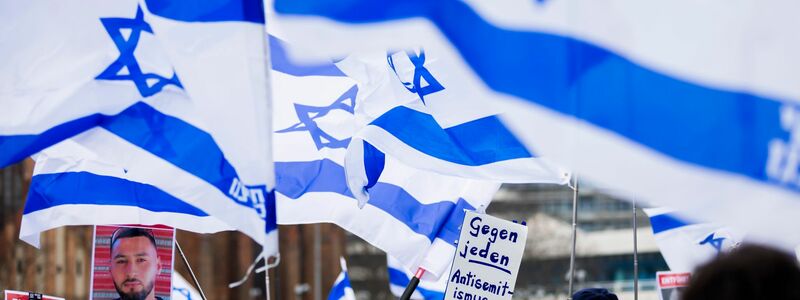 Menschen demonstrieren in Berlin mit Israelischen Fahnen gegen Antisemitismus und für Solidarität mit Israel. - Foto: Christoph Soeder/dpa