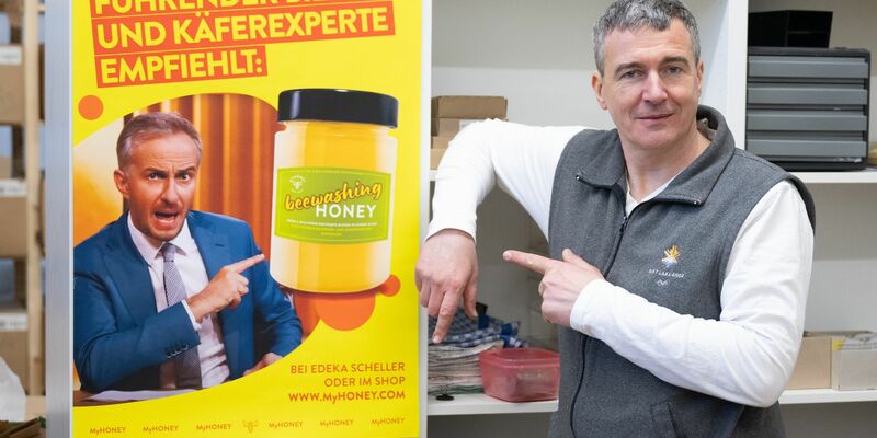 Imker Rico Heinzig neben einem Plakat mit dem Foto des Moderators Jan Böhmermann. - Foto: Sebastian Kahnert/dpa