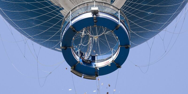 Israelische Angehörige von Hamas-Geiseln werfen Zettel mit Fotos der Verschleppten aus einem Heißluftballon in Berlin-Mitte. - Foto: Bernd von Jutrczenka/dpa